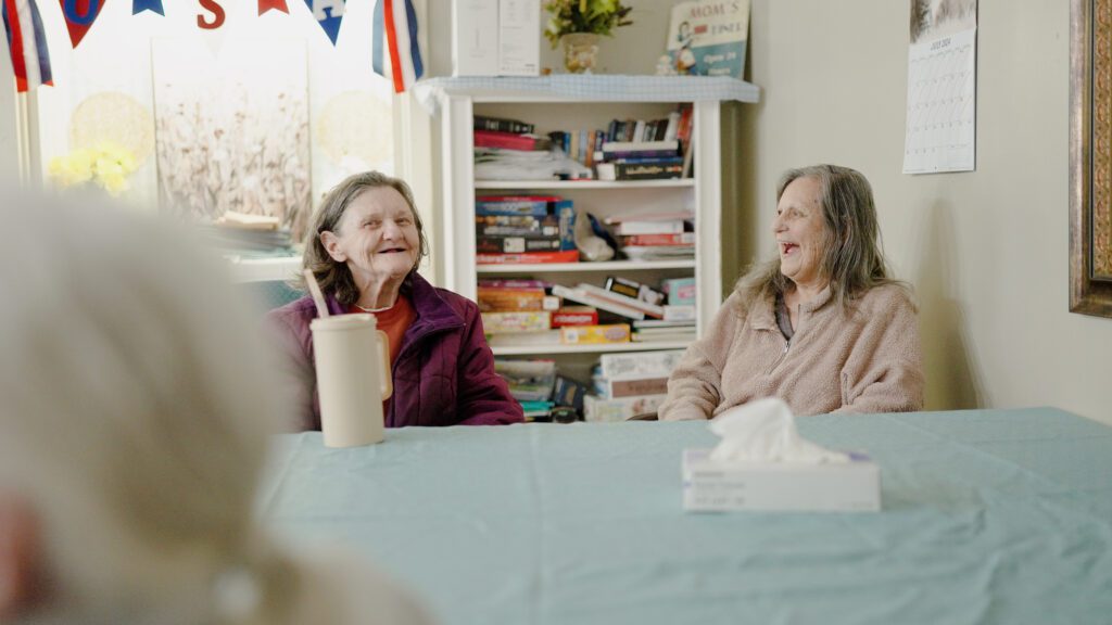 Two women smiling and laughing at a skilled nursing home