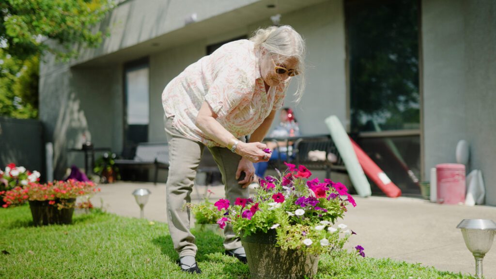 A woman working in a flower garden at a skilled nursing facility